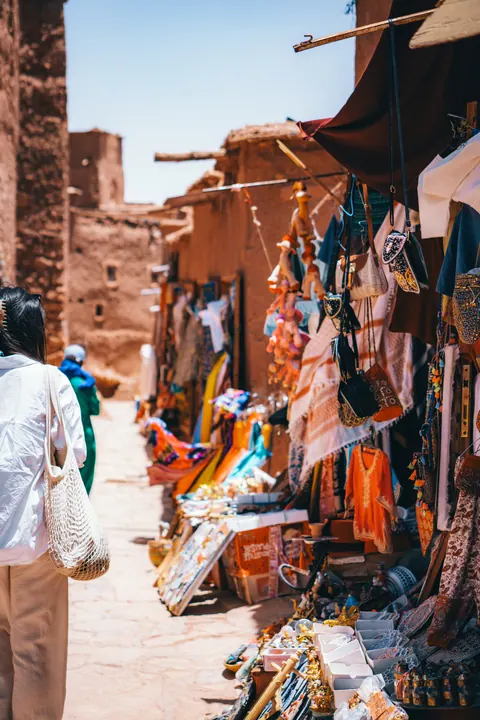 Moroccan market lane with local crafts and a traveler walking through